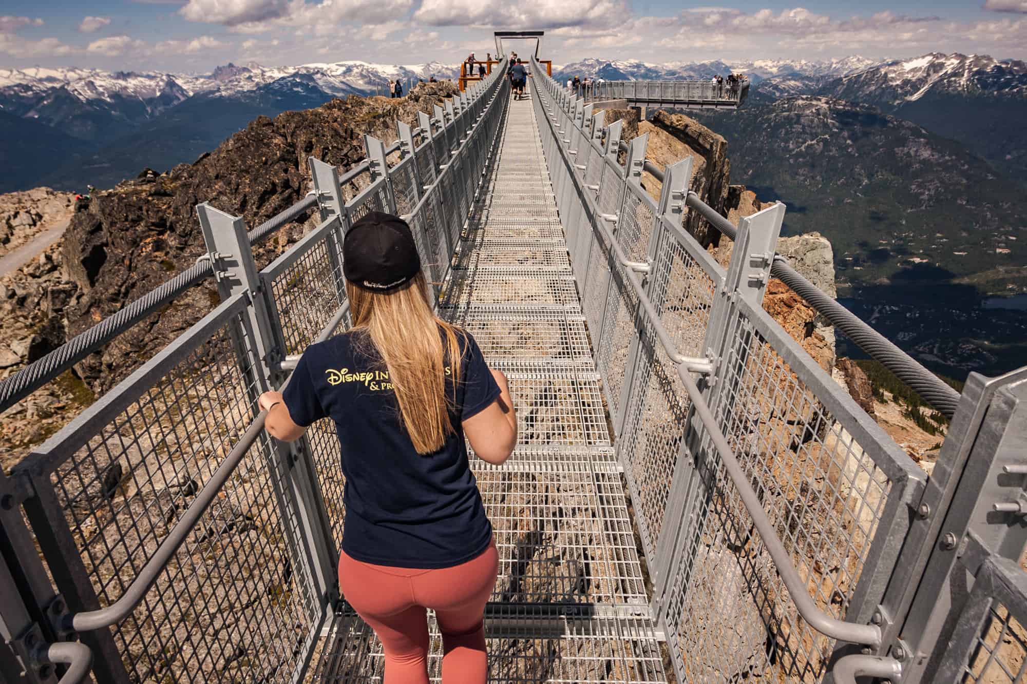 Rachael walking across the Cloudraker Skybridge - one of the things to consider when deciding "is the Peak 2 Peak gondola worth it?"