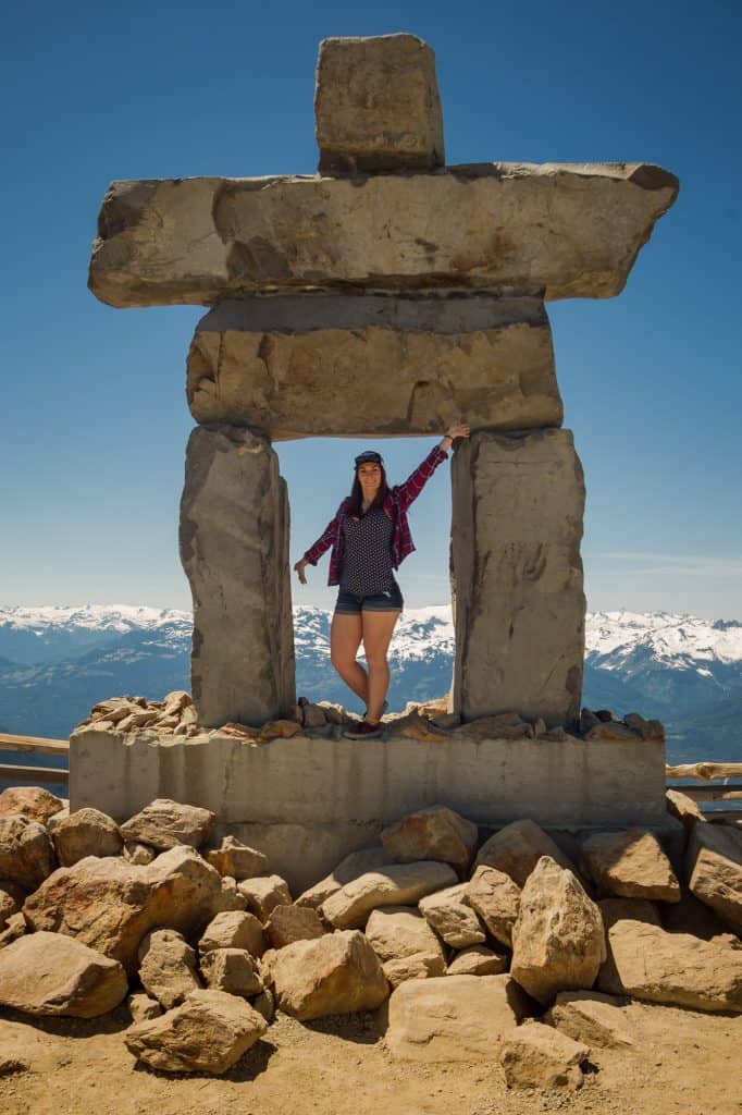 Rachael standing on the Inukshuk at the peak of Whistler Mountain.