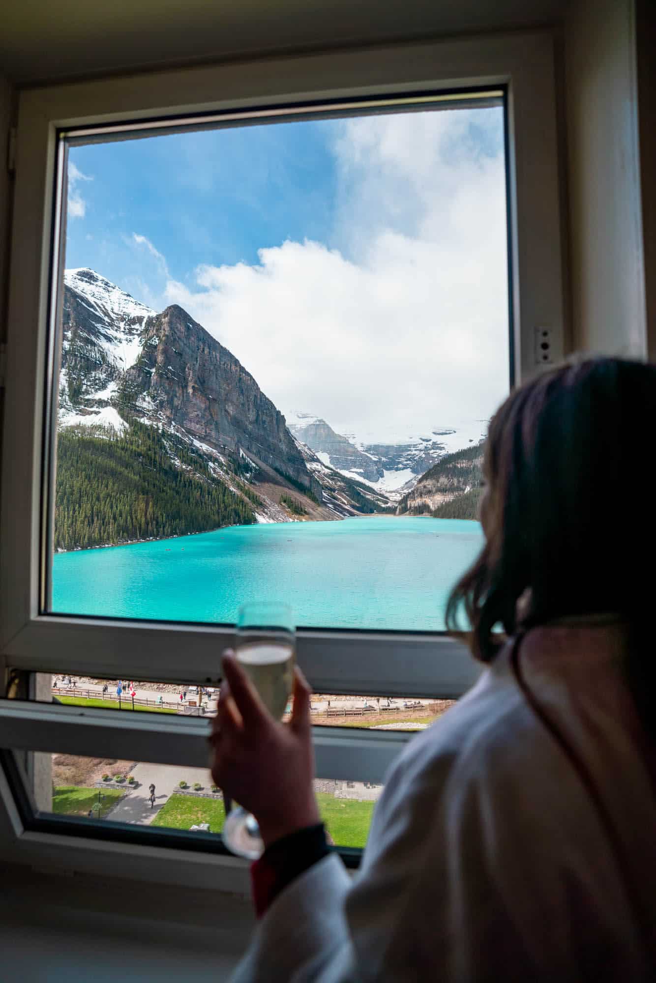 Rachael looking out the window at Lake Louise from a lake view room at the Fairmont Chateau Lake Louise.