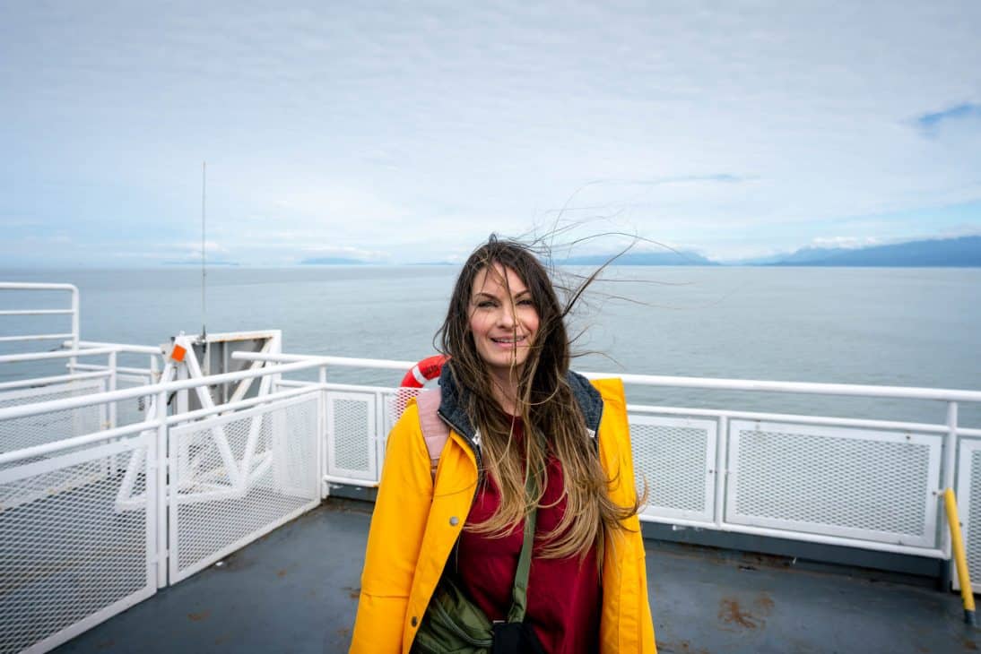 Woman on a ferry in the ocean with the wind blowing in her hair. 
