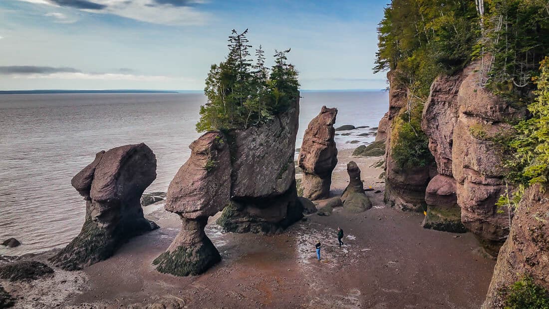 Photo of rock formations next to a rocky cliff and the ocean the other side. 