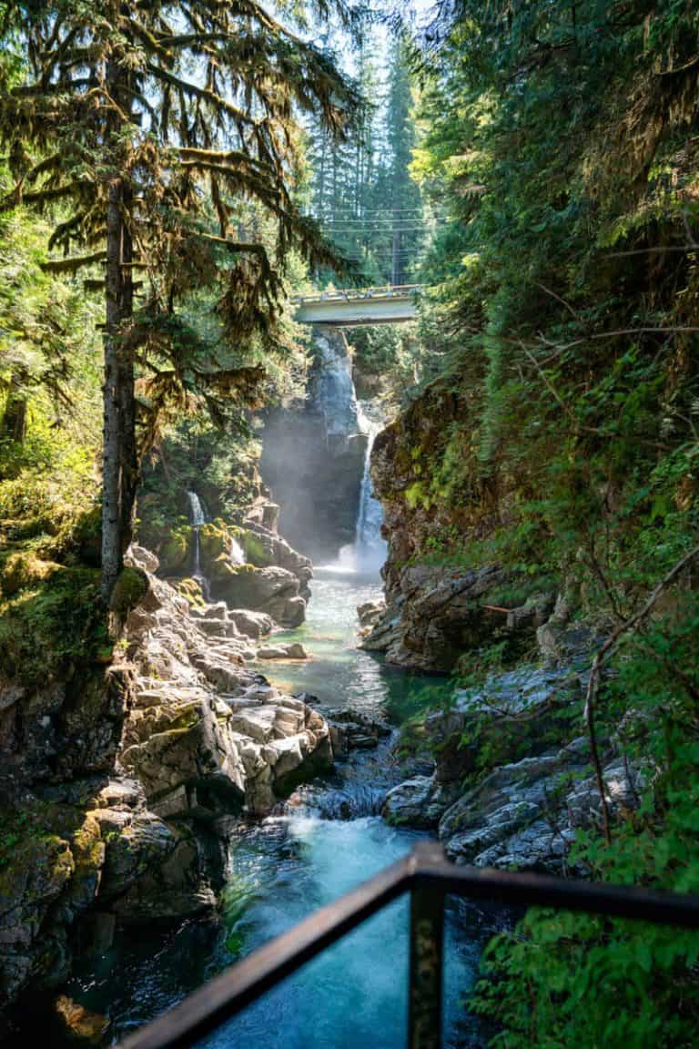 Photo of a rushing river through a canyon that leads to a small waterfall, surrounded by mossy rainforest. Mamquam falls is a easy hike in Squamish suitable for all fitness levels.