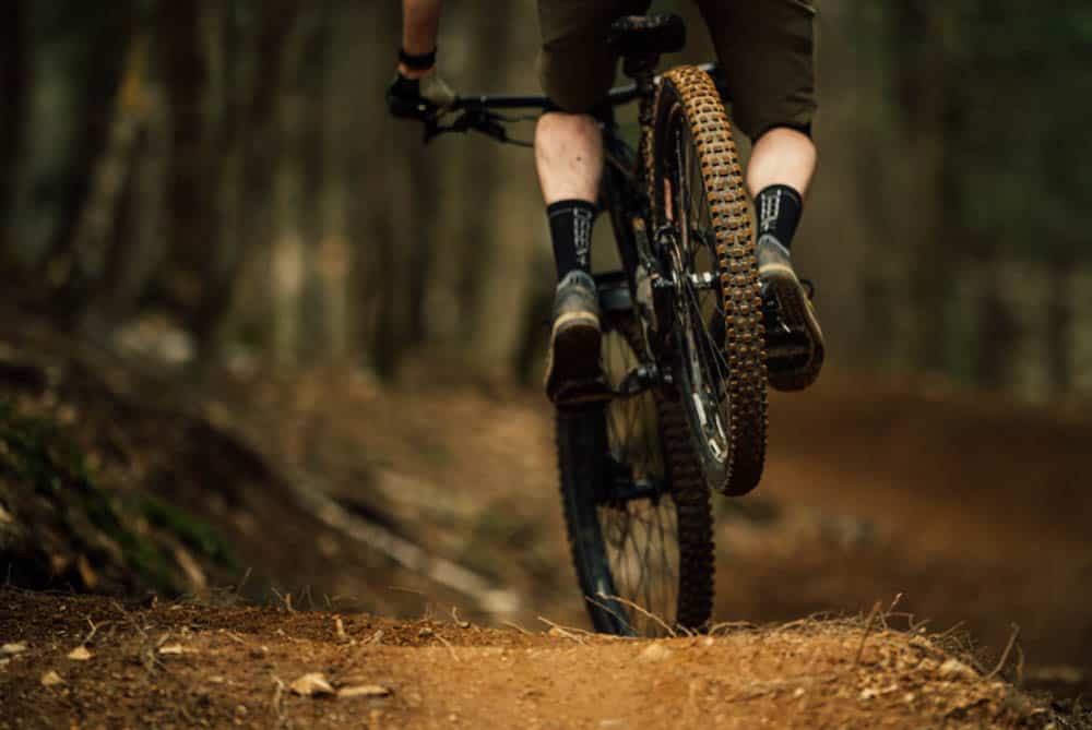Close up photo of a man riding a mountain bike in the forest. The bike ark is by far the best thing to do in Whistler in summer.